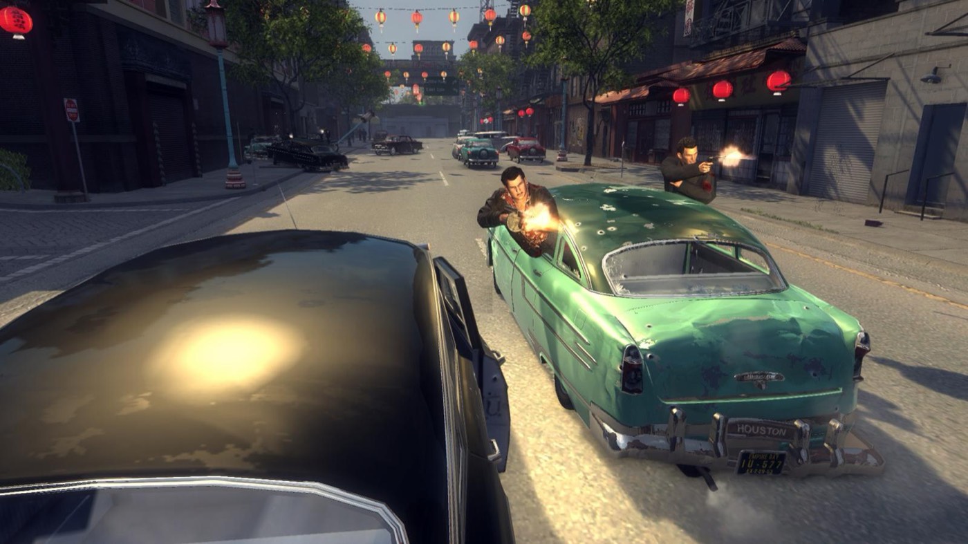 A drive-by shootout between two classic cars on a city street